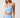 A woman modeling a light blue athletic set consisting of a ruched sports bra.