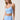 A woman modeling a light blue athletic set consisting of a ruched sports bra.