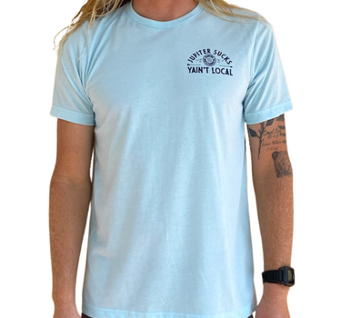 Person wearing a light blue t-shirt with Jupiter Sucks Yain't Local on the left chest,  on a white background