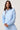 A woman modeling a light blue long-sleeve cropped hoodie.