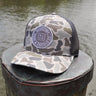 Duck camo UV performance hat featuring the original Blueline logo patch, designed for boating, fishing, golf, and outdoor adventures in Jupiter, Florida.