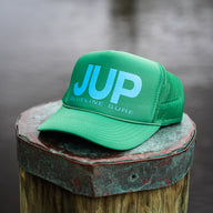 Otto JUP Hat in green and blue by Blueline Surf & Paddle Co., featuring blue gradient JUP logo on a foam mesh snapback, photographed in Jupiter, Florida.