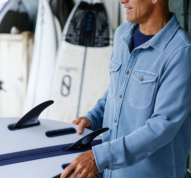 man wearing Outerknown blanket shirt holding surfboard coastal lifestyle Jupiter Florida