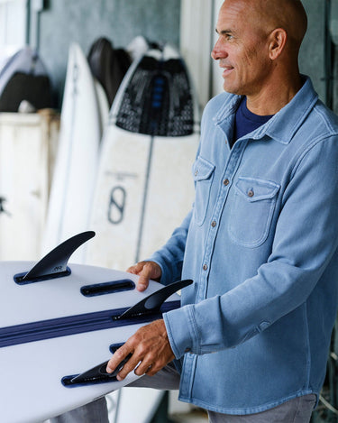 man wearing Outerknown blanket shirt holding surfboard coastal lifestyle Jupiter Florida