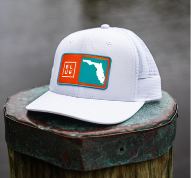 White cap with a colorful logo on a wooden post