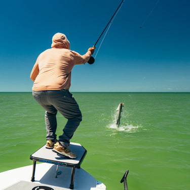 Man fishing from a boat wearing Poncho Rusty Pliers sun hoodie