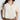 Woman wearing a beige and white patterned shirt against a white background