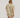 Person wearing a beige and white patterned shirt and shorts set on a plain background