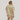 Person wearing a beige and white patterned shirt and shorts set on a plain background