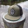 Olive and black Skully rope trucker hat from Blueline Surf & Paddle Co. featuring custom skull artwork and coastal performance styling inspired by the Jupiter Florida saltwater lifestyle.