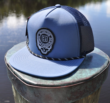 Slate gray and navy Skully rope trucker hat from Blueline Surf & Paddle Co. featuring custom skull artwork and coastal styling inspired by the Jupiter Florida saltwater lifestyle.