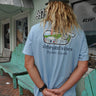 Back view of a person wearing a Jake Blue Vineyard Vines x Blueline t-shirt with a vintage storefront lighthouse graphic and Jupiter, Florida text.